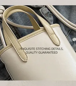 Close-up of cream PU handbag with contrast yellow handle and precise stitching detail
