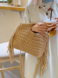Handmade beige crochet tote bag with fringe tassels and woven shoulder straps