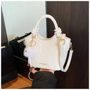 Détail du sac à main blanc texture serpent avec ferrures dorées et poignée à nœud