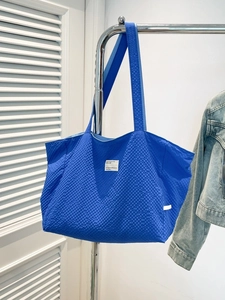 Sac fourre-tout bleu roi avec texture pop-corn et étiquette blanche minimaliste