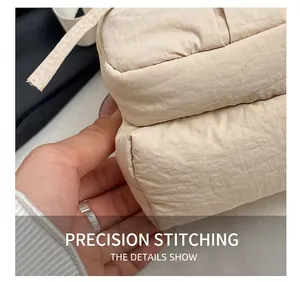 Macro shot of double-layer stitching and beige nylon fabric details on a crossbody bag