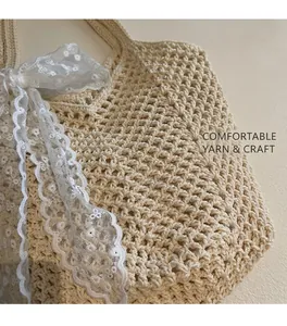 Gros plan sur le sac fourre-tout tissé beige avec maille en coton et nœud en dentelle