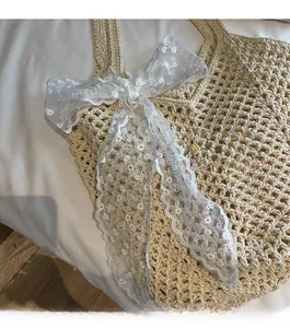 Gros plan détaillé du sac cabas tissé ivoire avec une grande décoration de nœud en dentelle