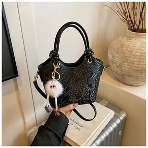 Détail du sac seau noir en cuir gaufré serpent avec breloque monstre et poignée nouée