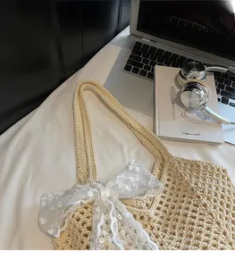 Détail du sac bandoulière tissé montrant le nœud en dentelle et la texture douce