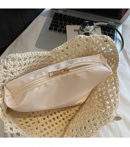 Détail du sac cabas tissé beige montrant la doublure en satin et le zip doré lisse