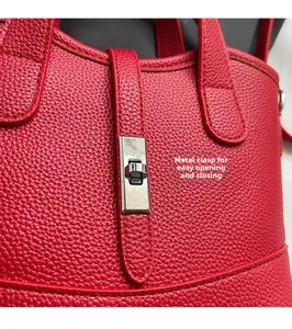 Dettaglio della chiusura in metallo argentato su borsa in pelle martellata rossa