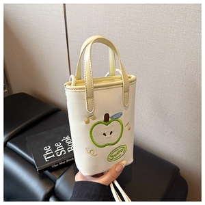 Close-up of cream mini tote bag with green apple embroidery and thin shoulder strap