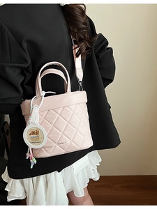 Pink quilted tote bag with Capybara charm and adjustable strap shown on model