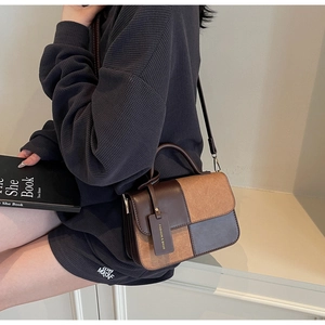 Detail of color-block crossbody bag featuring brown leather and camel suede patchwork