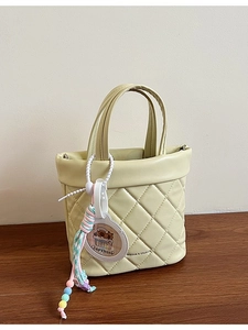 Quilted light yellow bucket handbag with rhombus stitching and cute Capybara charm
