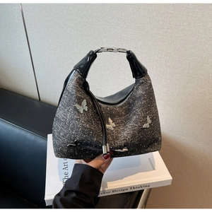 Détail du sac à main gris foncé scintillant orné de papillons métalliques argentés
