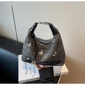 Detailansicht der grauen Tweed-Handtasche mit silbernen Schmetterlingen und Griff