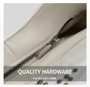 Close-up of white leather texture with silver metal zipper and round rivet details