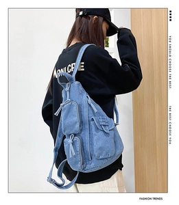 Detail eines blauen Denim-Rucksacks mit Taschen aus robustem, gewaschenem Jeansstoff
