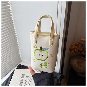 Close-up of apple embroidery and text details on a stylish cream mini handbag