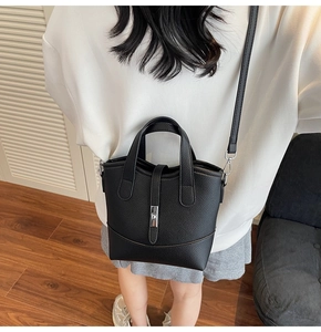 Vista posteriore di una borsa a secchiello in pelle nera con chiusura argento indossata da modella