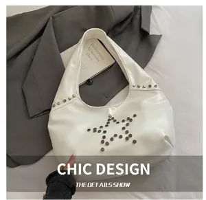 Close-up of white Hobo shoulder bag with silver metal studs in a star pattern