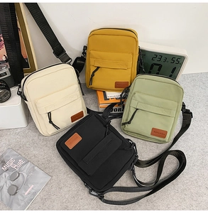 Multiple colorful nylon crossbody bags with adjustable straps in a lifestyle setting