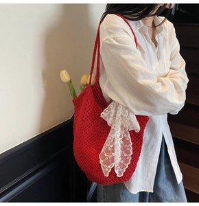 Détail du cabas au crochet rouge avec tissage artisanal et nœuds en dentelle blanche