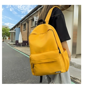 Detail of a bright yellow minimalist school backpack with CHYJO logo on a side pocket