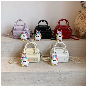 Five assorted colors of mini PU leather satchel bags with cute plush charms on stairs