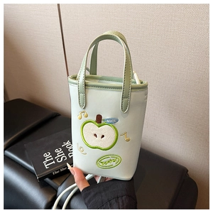 Detail of mint green apple-shaped mini bag featuring cute embroidery and nice texture