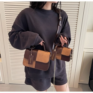 Detail of color-block handbags in two sizes with leather tags and metal chain straps