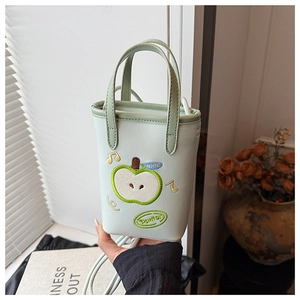 Detail shot of mint green apple embroidery and NICE text on a small PU leather crossbody bag
