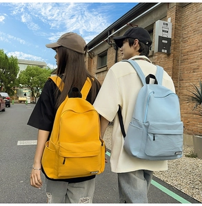 Outdoor shot of bright yellow and light blue casual nylon backpacks for students