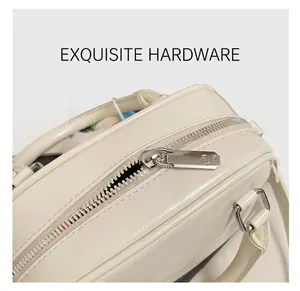 Detailed close-up of premium silver metal zipper and hardware on white leather handbag