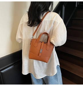 Close-up of caramel leather bucket bag featuring lychee texture and silver buckle detail