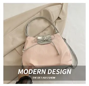 Detailed view of pink fabric tote bag with silver flap and elegant bow ribbon decoration