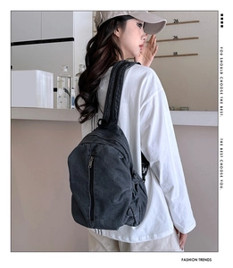 Détail du sac à dos en denim gris foncé avec boucles latérales et texture vintage
