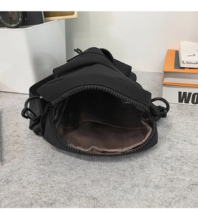 Detail of crossbody bag interior with brown lining, pocket, and durable zipper closure