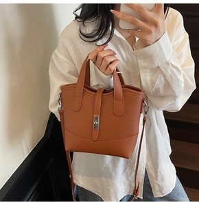 Borsa tote in pelle marrone con chiusura girevole in metallo in un selfie allo specchio