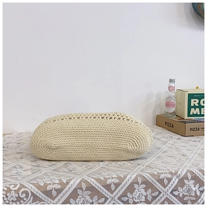 Detail of handmade cream crochet texture on a large capacity straw beach shoulder bag