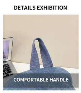 Vue détaillée de la poignée supérieure confortable de ce sac à dos en denim bleu