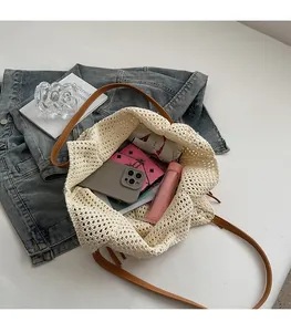 Top view of beige knit tote bag with leather handles showing spacious interior and daily items
