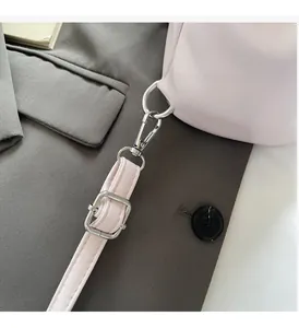 Dettaglio della borsa in ecopelle rosa con fibbie metalliche argentate e moschettone