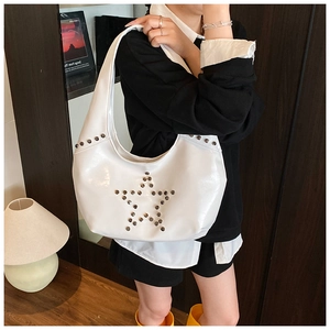 Detail of white glossy leather hobo bag with silver star rivets shown on shoulder