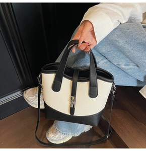 Close-up of contrast bucket bag showing litchi grain leather texture and metal buckle