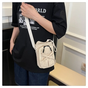 Beige nylon crossbody bag with bow detail and double zippers shown on a model