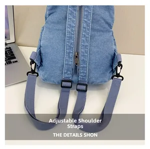 Détails des bretelles grises réglables et du zip arrière d'un sac à dos en jean
