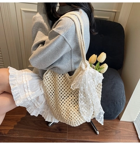 Détail d'un sac cabas tissé ajouré avec nœud en dentelle blanche et fleurs internes