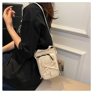 Crossbody bag in beige nylon with decorative bow and drawstring closure on female model