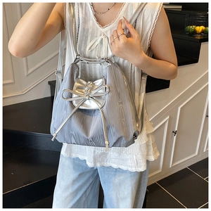 Detail of silver tote bag with large bow decoration and drawstring closure for women
