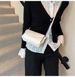 Détail d'un sac à bandoulière en cuir grainé blanc crème avec rabat et sangle