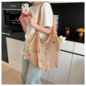 Détail du sac cabas en tricot avec paillettes colorées et glands en cuir sur la bandoulière