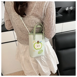 Detail of mint green apple-shaped crossbody bag with decorative embroidery and handle
